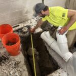 Measuring hole for new pipes in basement floor